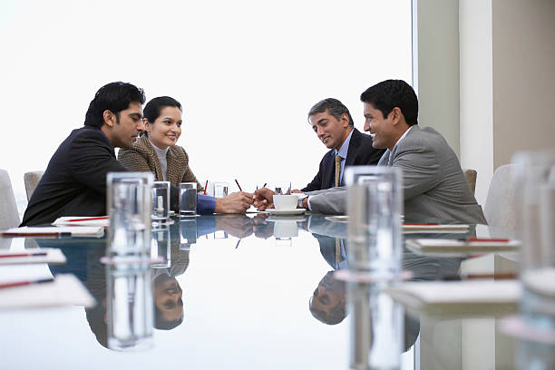 Four Indian business people discussing at conference table